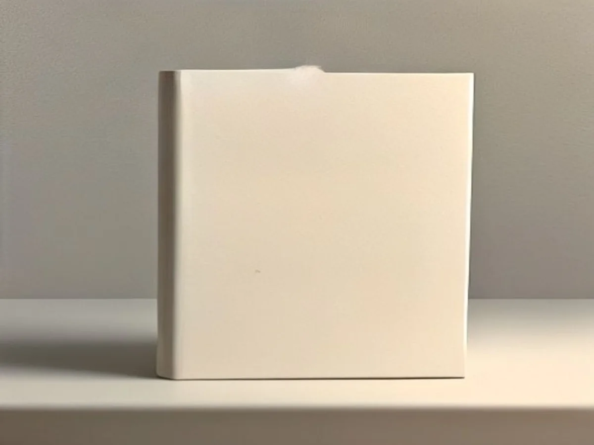 A single open book with blank pages on a calm cream table, a minimal oil painting.