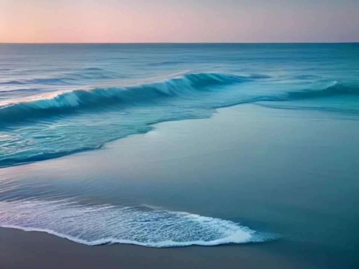 The Atlantic coastline with dark rocks softened by haze and a single teal light glow.