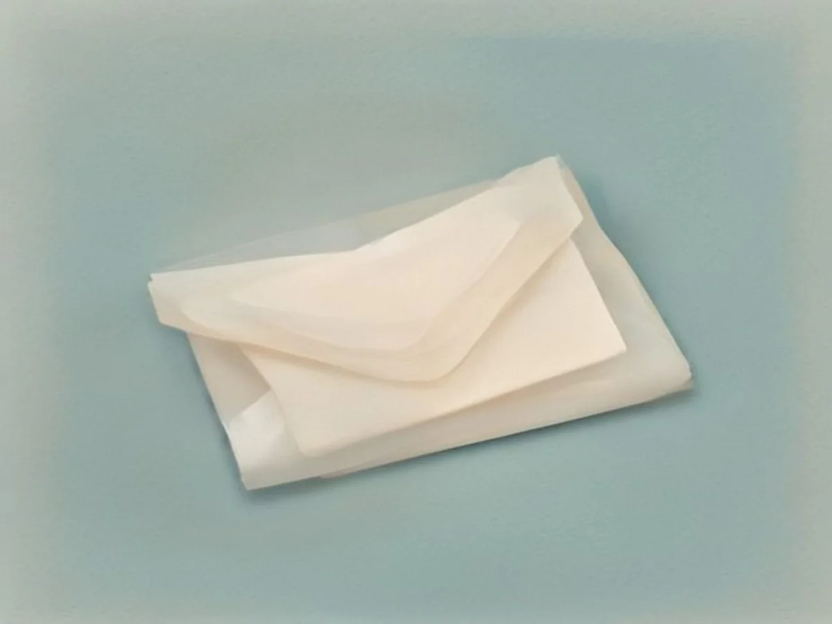 A single cream envelope resting on warm linen, a minimal oil painting.
